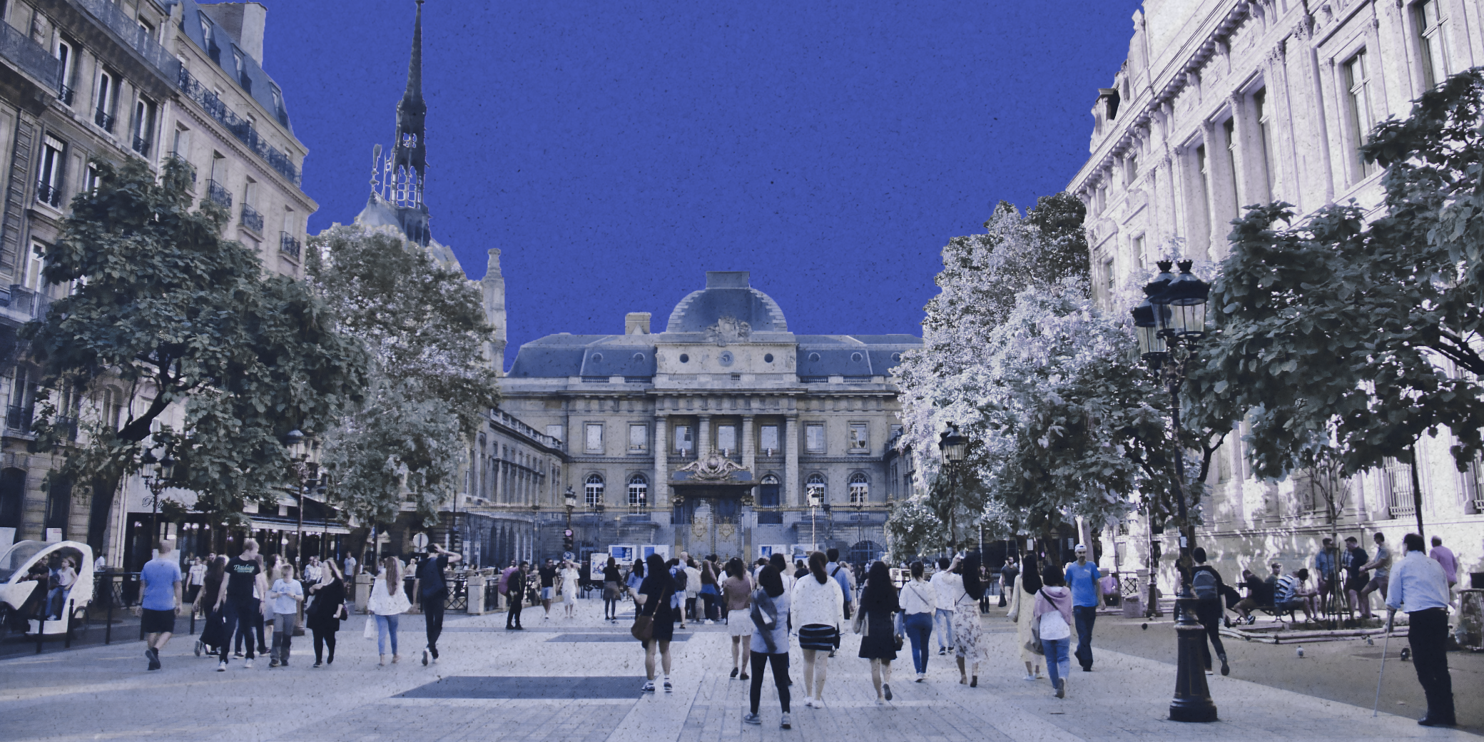 European square with people walking and a historic building, in blue tones.