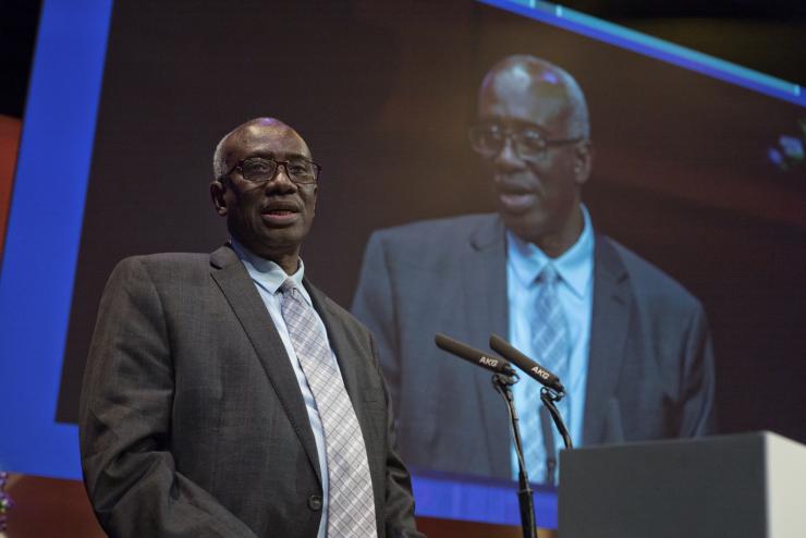 A man presents on stage at the Forum