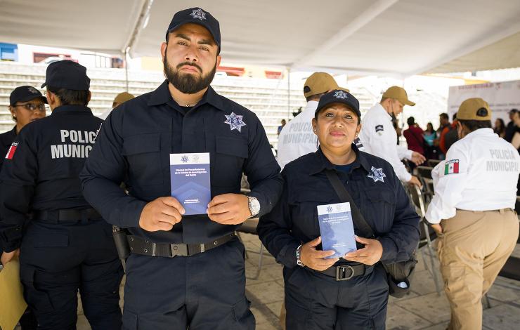 Two police offers in Oaxaca hold up WJP MX manuals on criminal investigation
